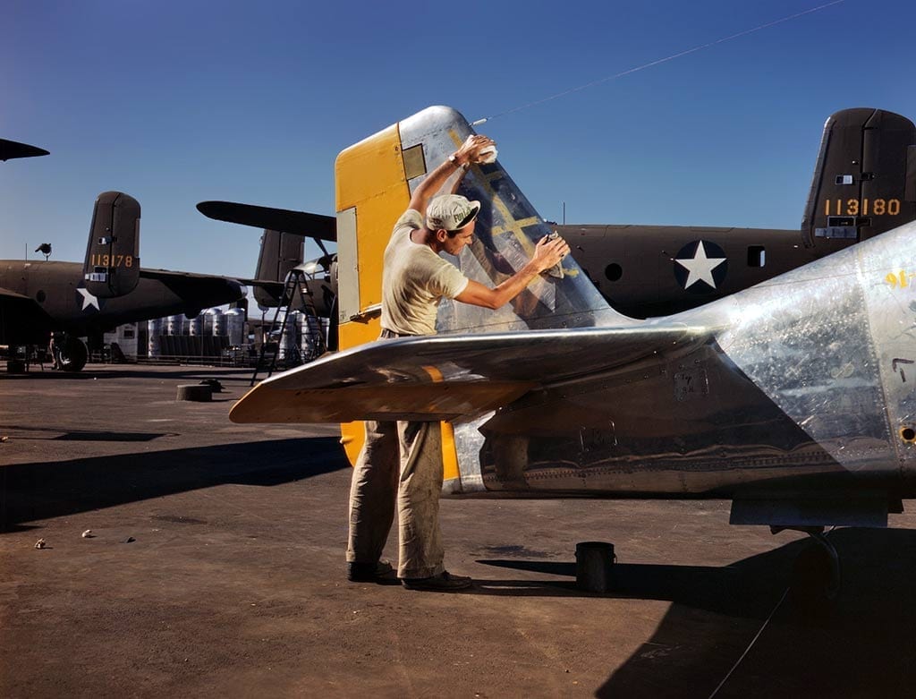 Crewman polishing a P-51 Mustang fin